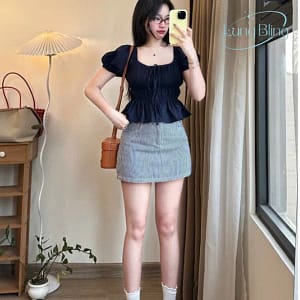 Áo nhún eo tạo đường cong nhẹ nhàng, kết hợp chân váy ngắn mang lại vẻ ngoài trẻ trung, phù hợp với dáng chubby
